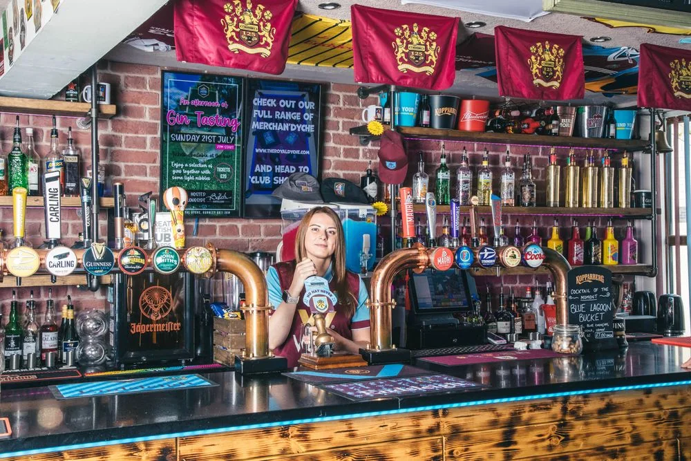 An EFL supporter in a pub decorated with club flags and memorabilia
