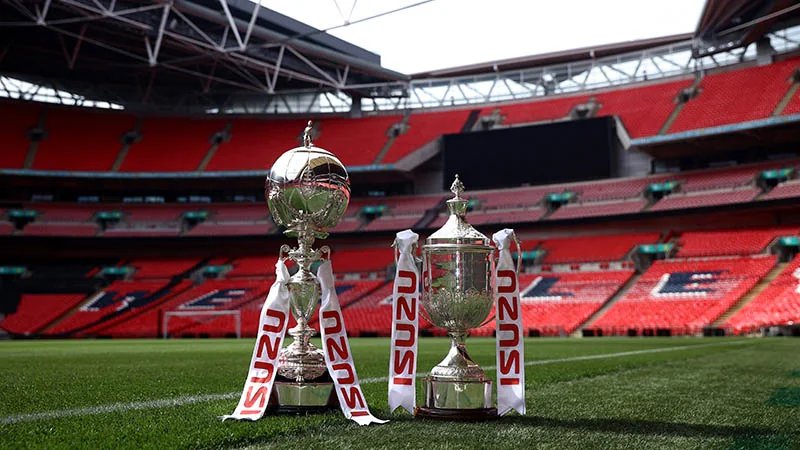 FA Trophy and FA Vase displayed on the pitch at Wembley Stadium