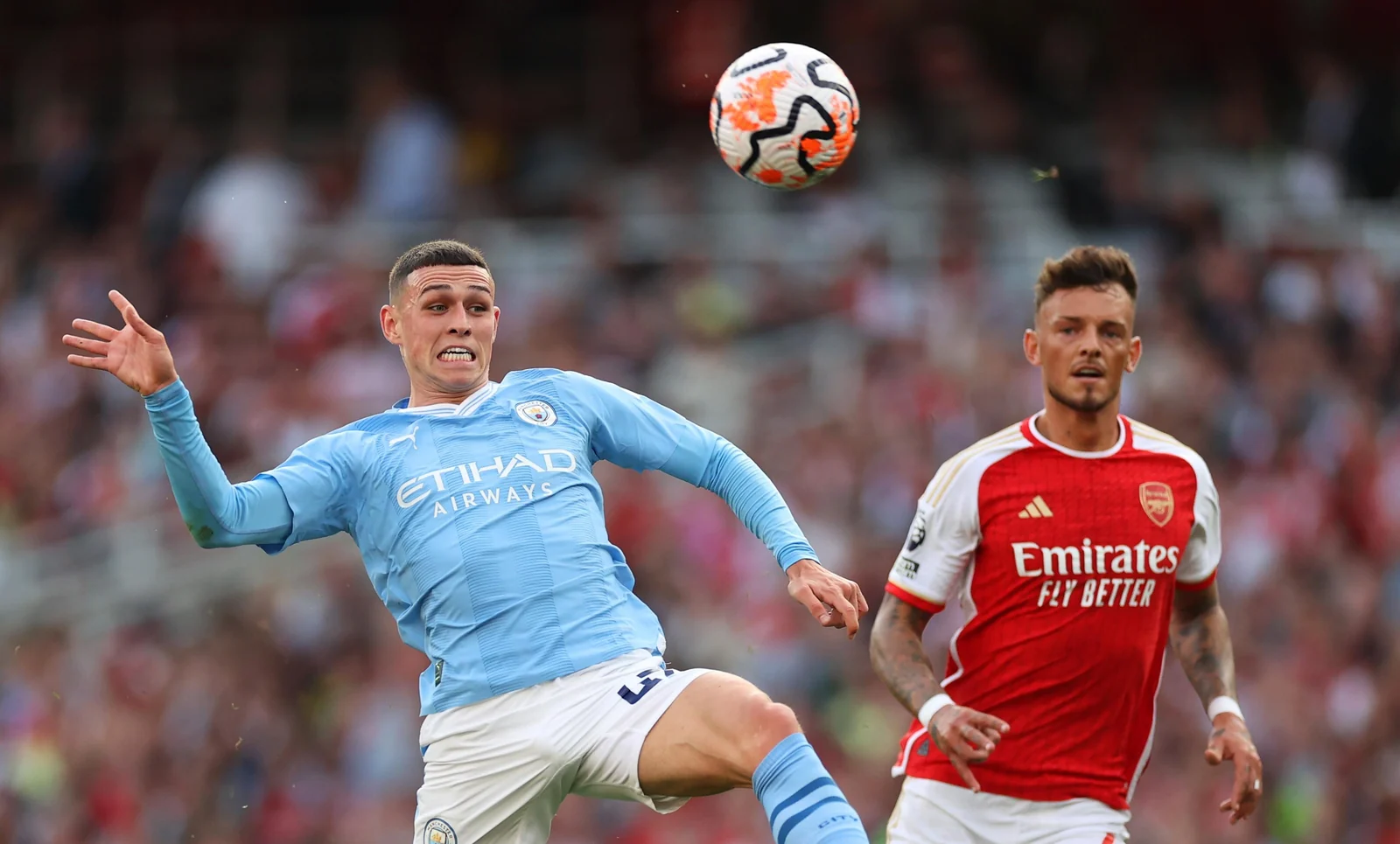 Phil Foden and Ben White competing in a Premier League match